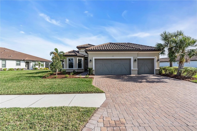 mediterranean / spanish-style home featuring a front yard and a garage