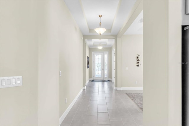 entryway featuring a raised ceiling and light tile patterned flooring