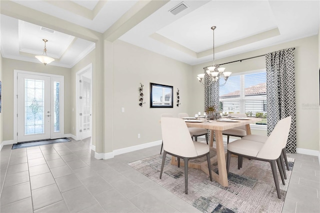 tiled dining area featuring a raised ceiling, plenty of natural light, ornamental molding, and a notable chandelier