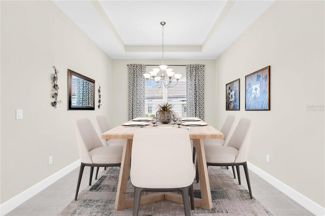 dining space featuring a notable chandelier, light tile patterned flooring, and a raised ceiling