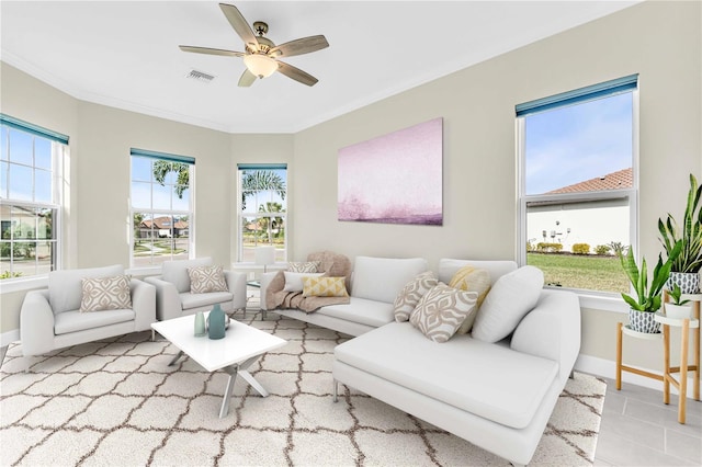 living room featuring ceiling fan, light tile patterned floors, and crown molding