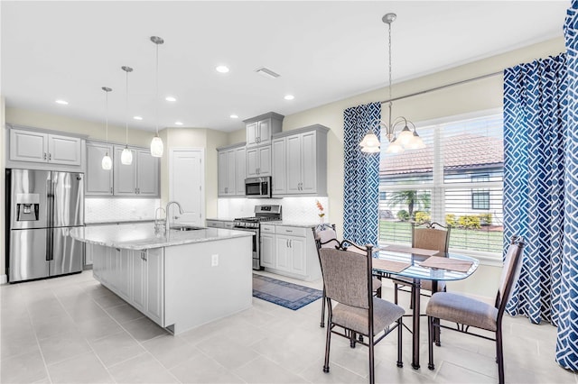 kitchen featuring gray cabinetry, an inviting chandelier, hanging light fixtures, and appliances with stainless steel finishes