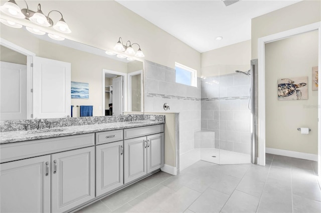 bathroom featuring a tile shower, tile patterned flooring, and vanity