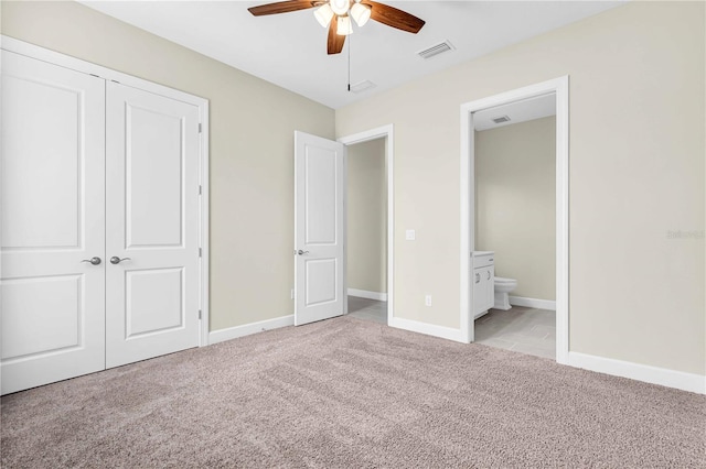 unfurnished bedroom with connected bathroom, a closet, ceiling fan, and light colored carpet