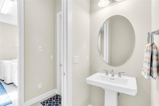 bathroom featuring tile patterned flooring, independent washer and dryer, and sink