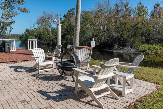 view of patio featuring a water view and an outdoor fire pit