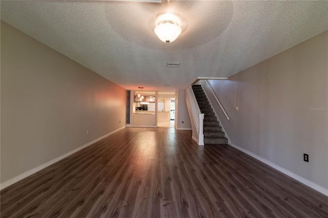 unfurnished living room with dark hardwood / wood-style floors and a textured ceiling