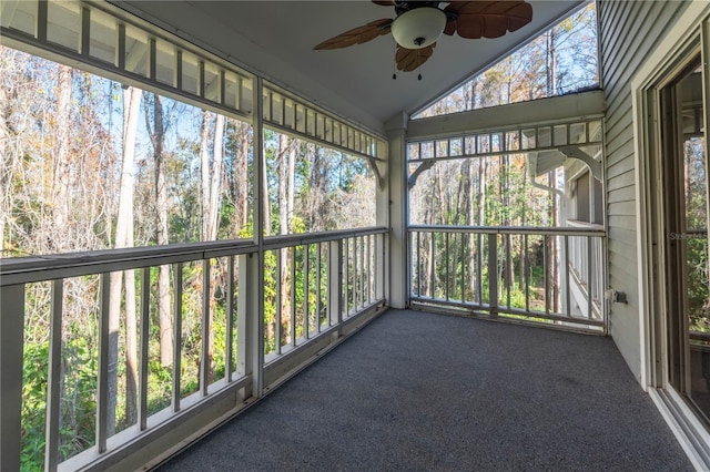 unfurnished sunroom with ceiling fan, a healthy amount of sunlight, and vaulted ceiling