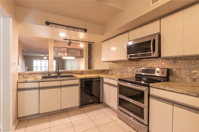 kitchen with white cabinets, light tile patterned floors, sink, and appliances with stainless steel finishes