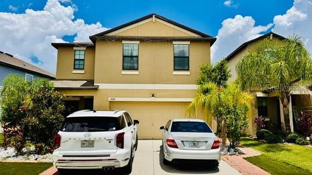 view of property featuring a garage and a front lawn