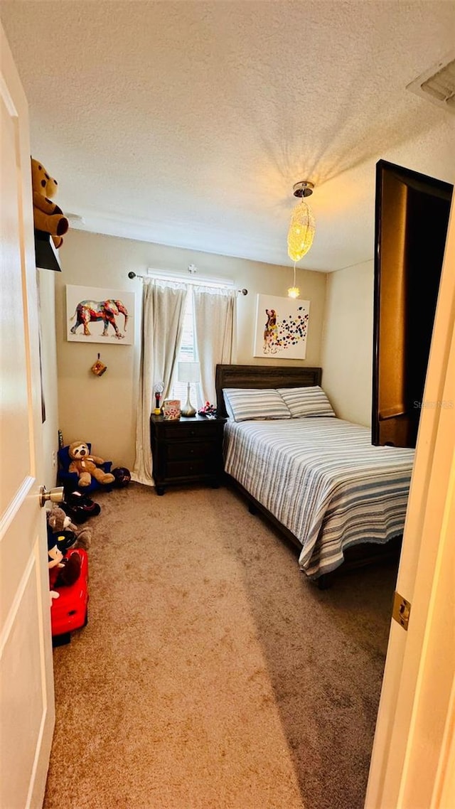 bedroom featuring carpet flooring and a textured ceiling