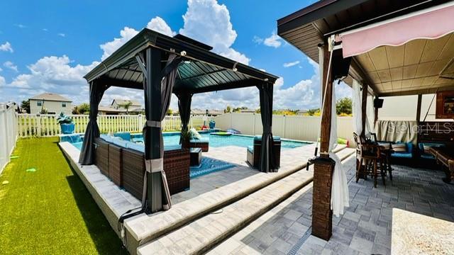 view of patio featuring a gazebo, outdoor lounge area, and a fenced in pool