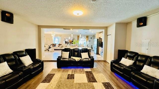 living room with wood-type flooring and a textured ceiling