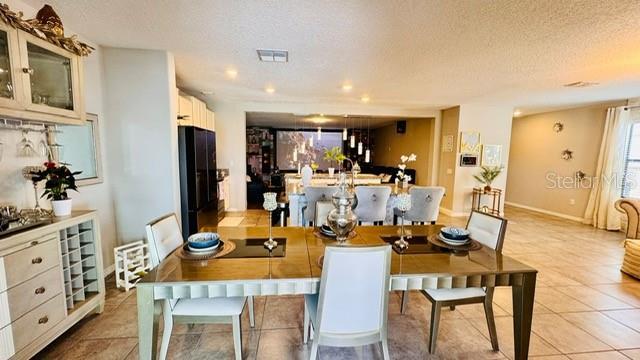 tiled dining room featuring a textured ceiling