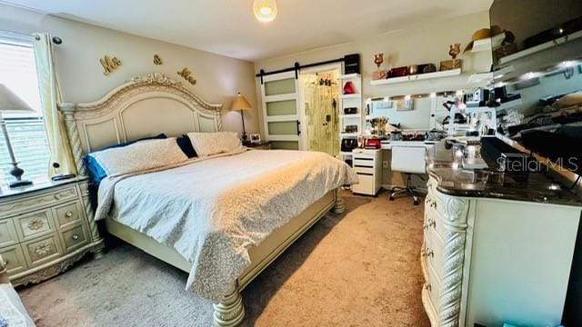 carpeted bedroom with a barn door