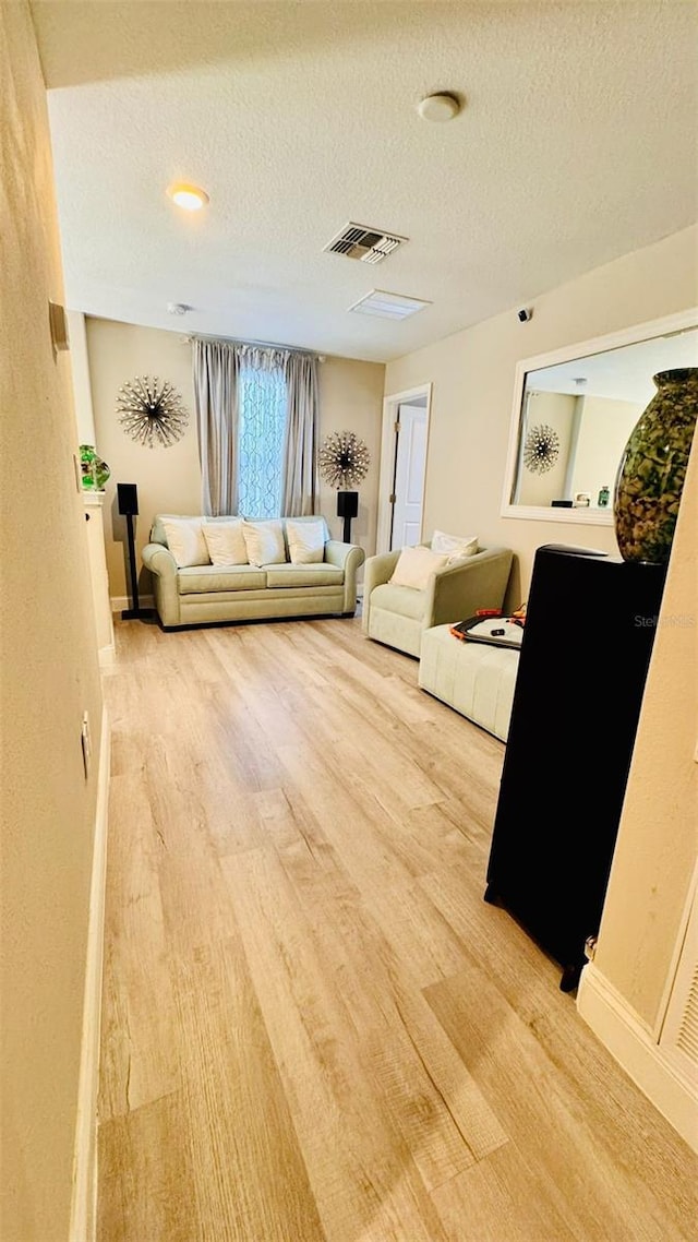 living room with wood-type flooring and a textured ceiling