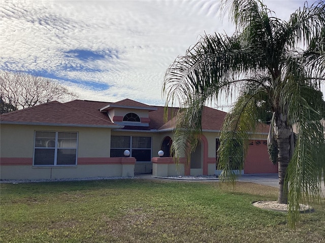 single story home featuring a garage and a front lawn