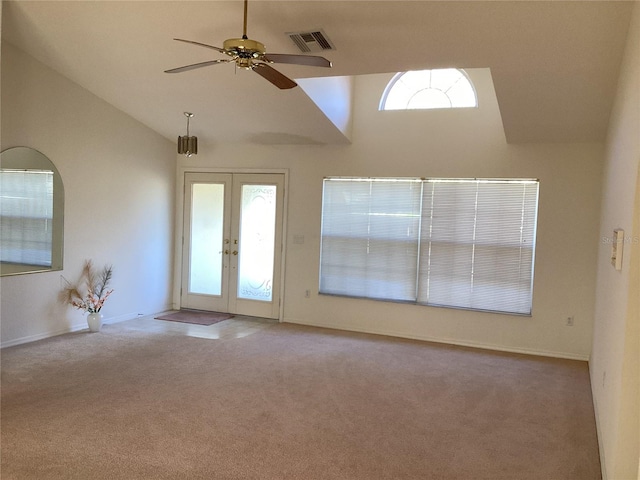 carpeted empty room featuring ceiling fan, french doors, and high vaulted ceiling