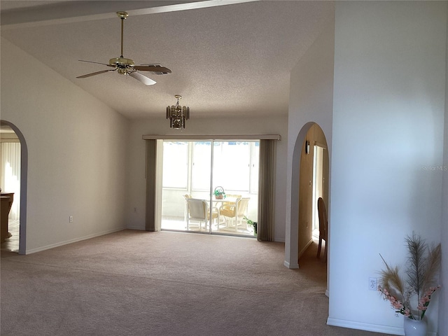 carpeted spare room featuring ceiling fan with notable chandelier, a textured ceiling, and high vaulted ceiling