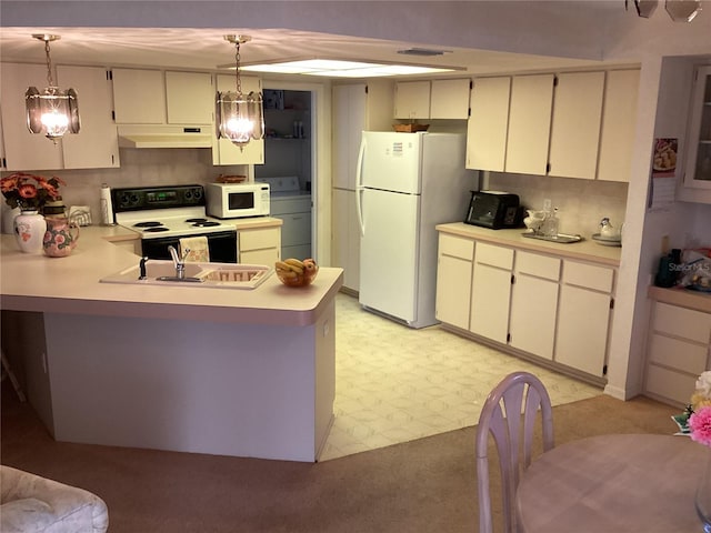 kitchen with pendant lighting, white appliances, kitchen peninsula, and washer / clothes dryer