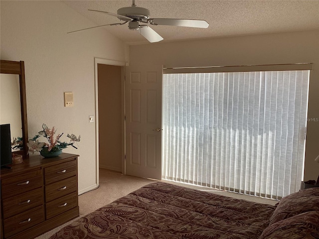 bedroom with a textured ceiling, light colored carpet, vaulted ceiling, and ceiling fan