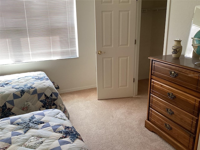 bedroom with light colored carpet and a closet