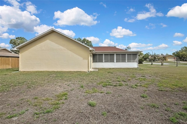10412 Ireland St, Spring Hill, FL 34608 - back of house featuring stucco siding, a sunroom, fence, and a yard