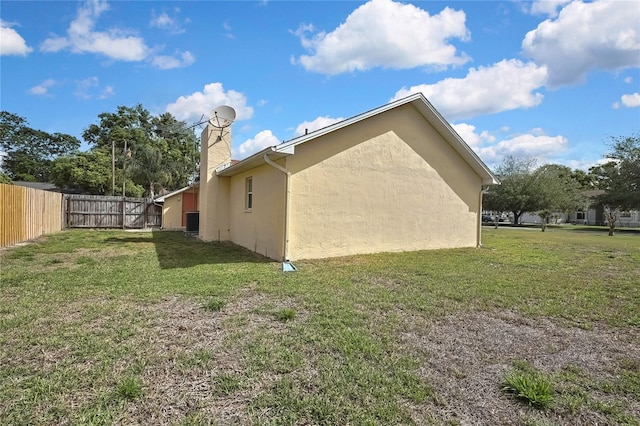 10412 Ireland St, Spring Hill, FL 34608 - view of home's exterior with fence, stucco siding, a yard, and a chimney