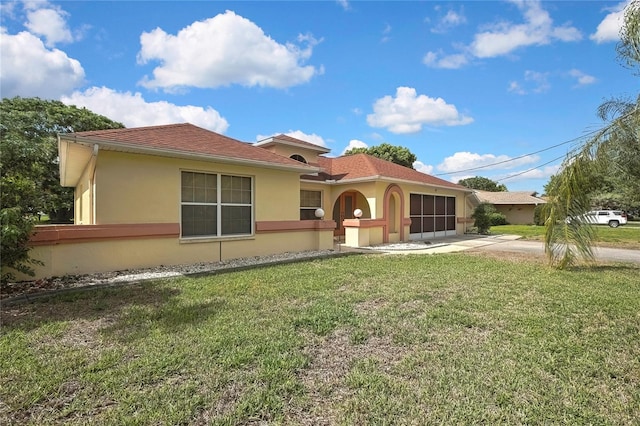 10412 Ireland St, Spring Hill, FL 34608 - mediterranean / spanish-style home with a front yard, a garage, concrete driveway, and stucco siding