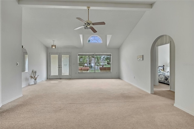 10412 Ireland St, Spring Hill, FL 34608 - unfurnished living room featuring carpet flooring, beamed ceiling, a ceiling fan, arched walkways, and french doors