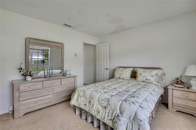 10412 Ireland St, Spring Hill, FL 34608 - bedroom with light carpet, a textured ceiling, and visible vents