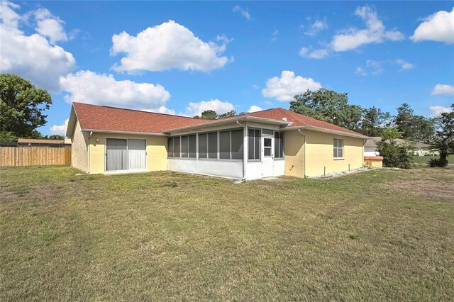 10412 Ireland St, Spring Hill, FL 34608 - back of property featuring stucco siding, a sunroom, fence, and a yard