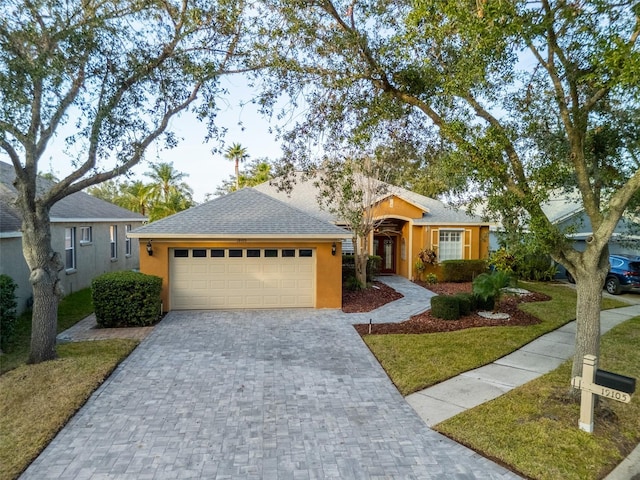 single story home featuring a garage and a front lawn