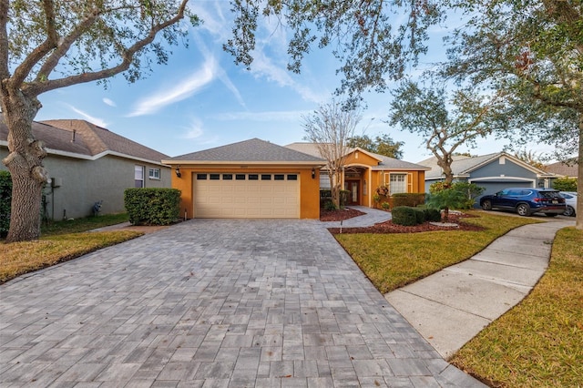 single story home featuring a garage and a front yard