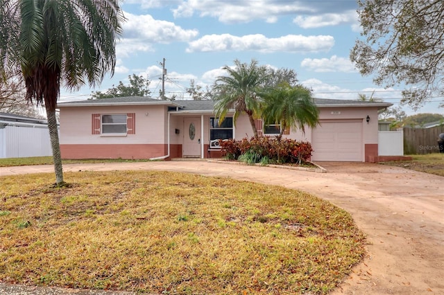 ranch-style home featuring a garage and a front lawn