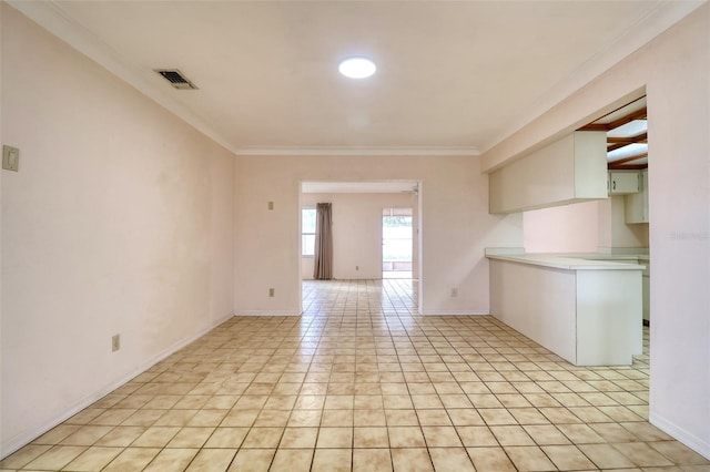 spare room with ornamental molding and light tile patterned floors