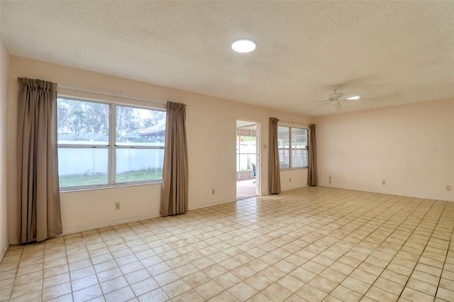 unfurnished room with ceiling fan and a textured ceiling