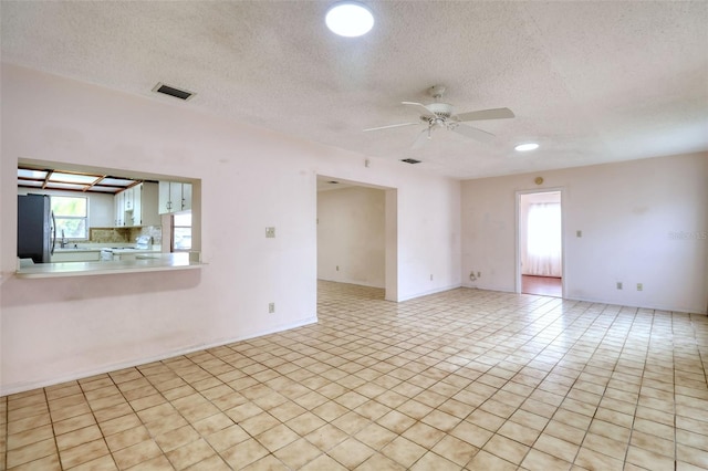 unfurnished room featuring ceiling fan and a textured ceiling