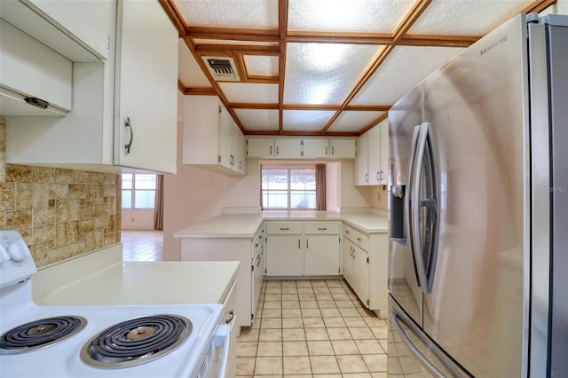 kitchen featuring white electric stove, stainless steel refrigerator with ice dispenser, light tile patterned floors, and white cabinets