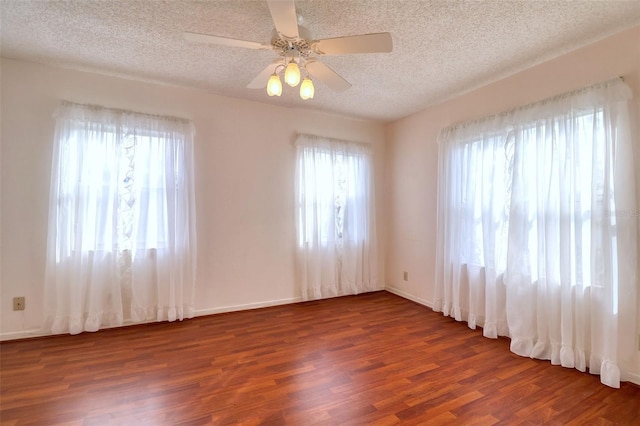 spare room featuring ceiling fan, dark wood-type flooring, and a textured ceiling