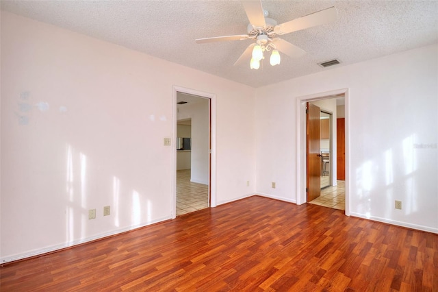 spare room featuring ceiling fan, a textured ceiling, and light hardwood / wood-style flooring