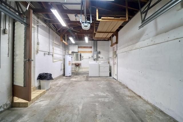 basement featuring concrete block wall, electric panel, separate washer and dryer, and electric water heater