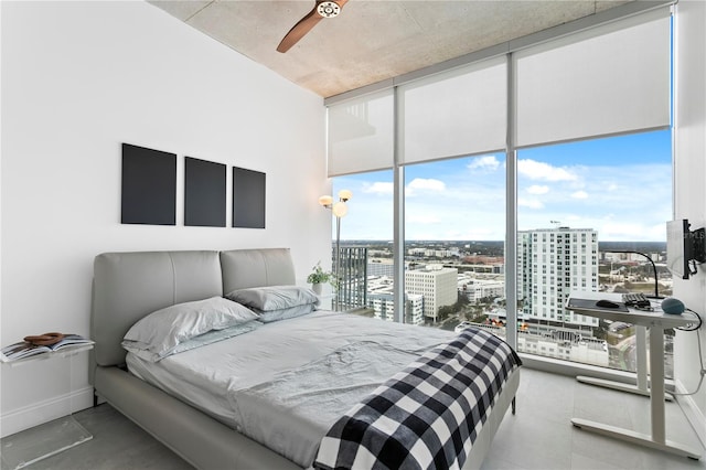 bedroom with multiple windows, floor to ceiling windows, and ceiling fan