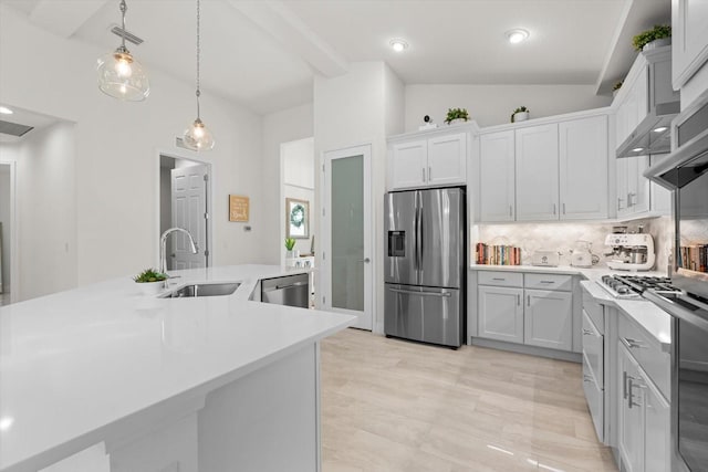 kitchen featuring white cabinets, sink, vaulted ceiling, decorative backsplash, and stainless steel appliances