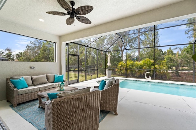 view of swimming pool with ceiling fan, an outdoor hangout area, a patio, and glass enclosure