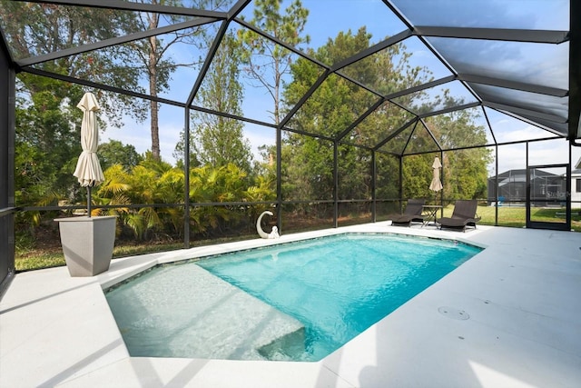 view of swimming pool with glass enclosure and a patio