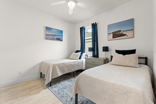 bedroom with ceiling fan, light wood finished floors, and baseboards