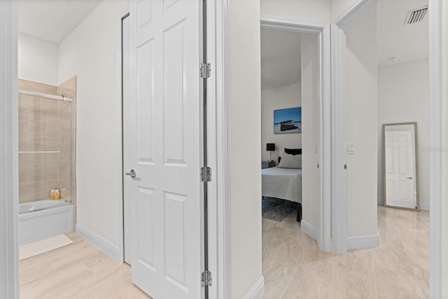 ensuite bathroom featuring shower / washtub combination, visible vents, connected bathroom, and baseboards