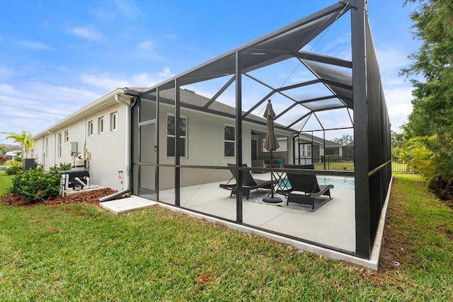 back of house featuring an outdoor pool, a lawn, glass enclosure, a patio area, and stucco siding