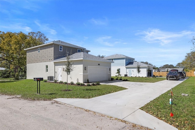 view of side of home with a yard, stucco siding, concrete driveway, an attached garage, and central AC